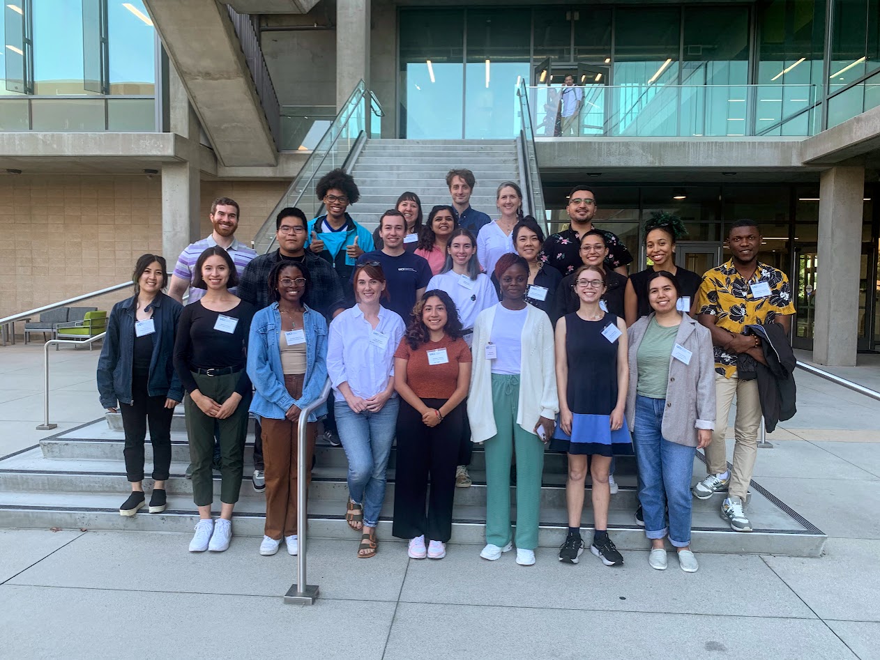All CJI fellows, Dr. Kathleen Johnson, postdocs James and Thi, academic coordinator Robert posing in front of Interdisciplinary Sciences Building